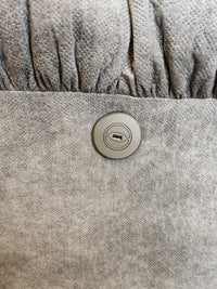 Close-up of a round metal lock on gray fabric—part of the Best 7MP84 Ellisport Power Space Saver Recliner.