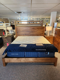 The Vokes 247 Vokes Saugeen King Bed Frame, with mattress, is displayed in a Canadian furniture showroom.