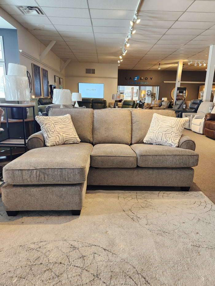 The Decor-rest 2285 Sofa with Chaise, gray with sinuous springs and two patterned cushions, is shown in the showroom.