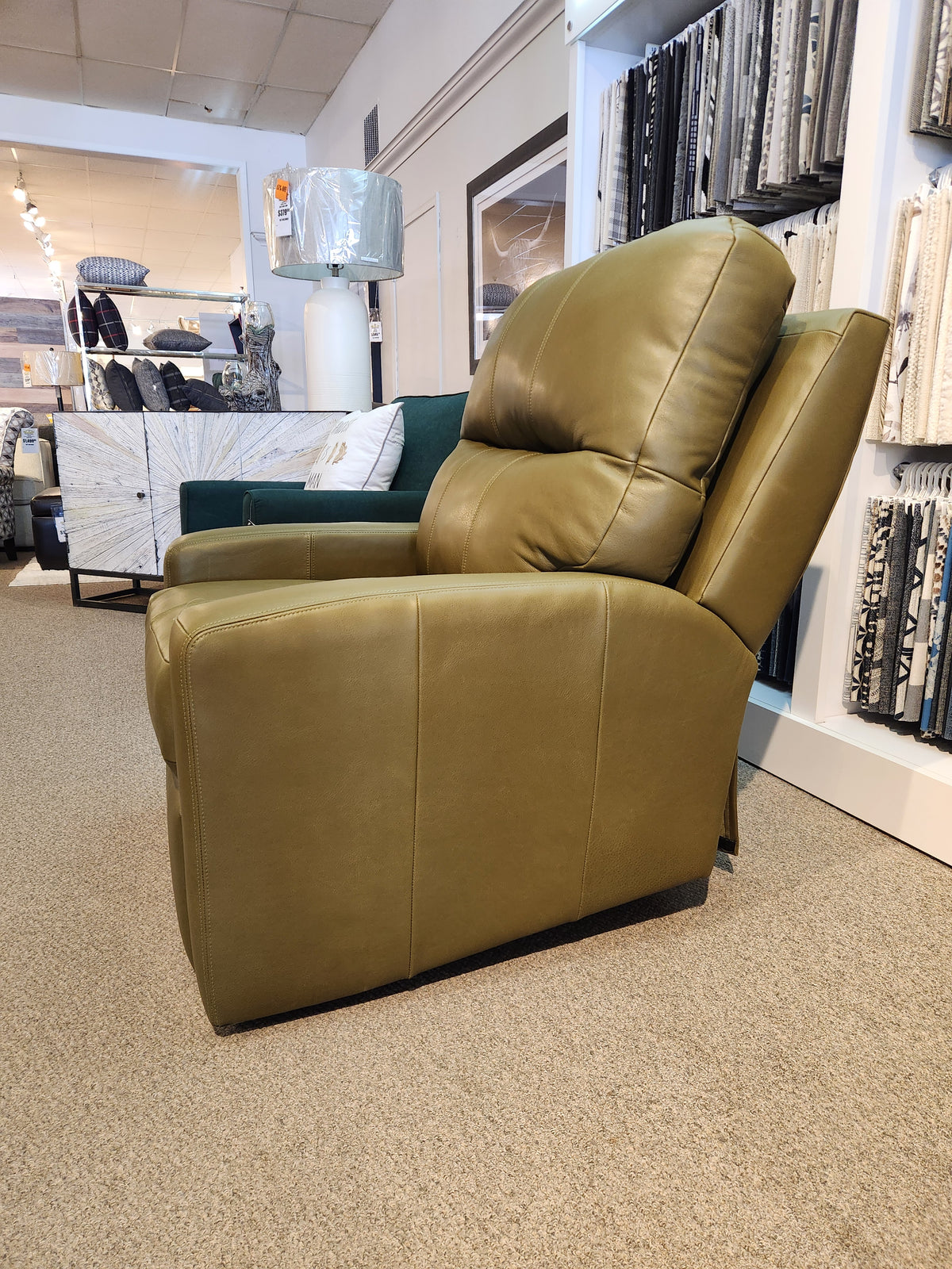The Decor-rest M38505 Power Reclining Chair in green is shown with a headrest and fabric samples in the background.