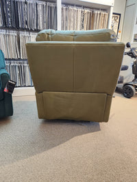 Rear view of a green Decor-rest M38505 Power Reclining Chair with headrest, fabric samples in the background.