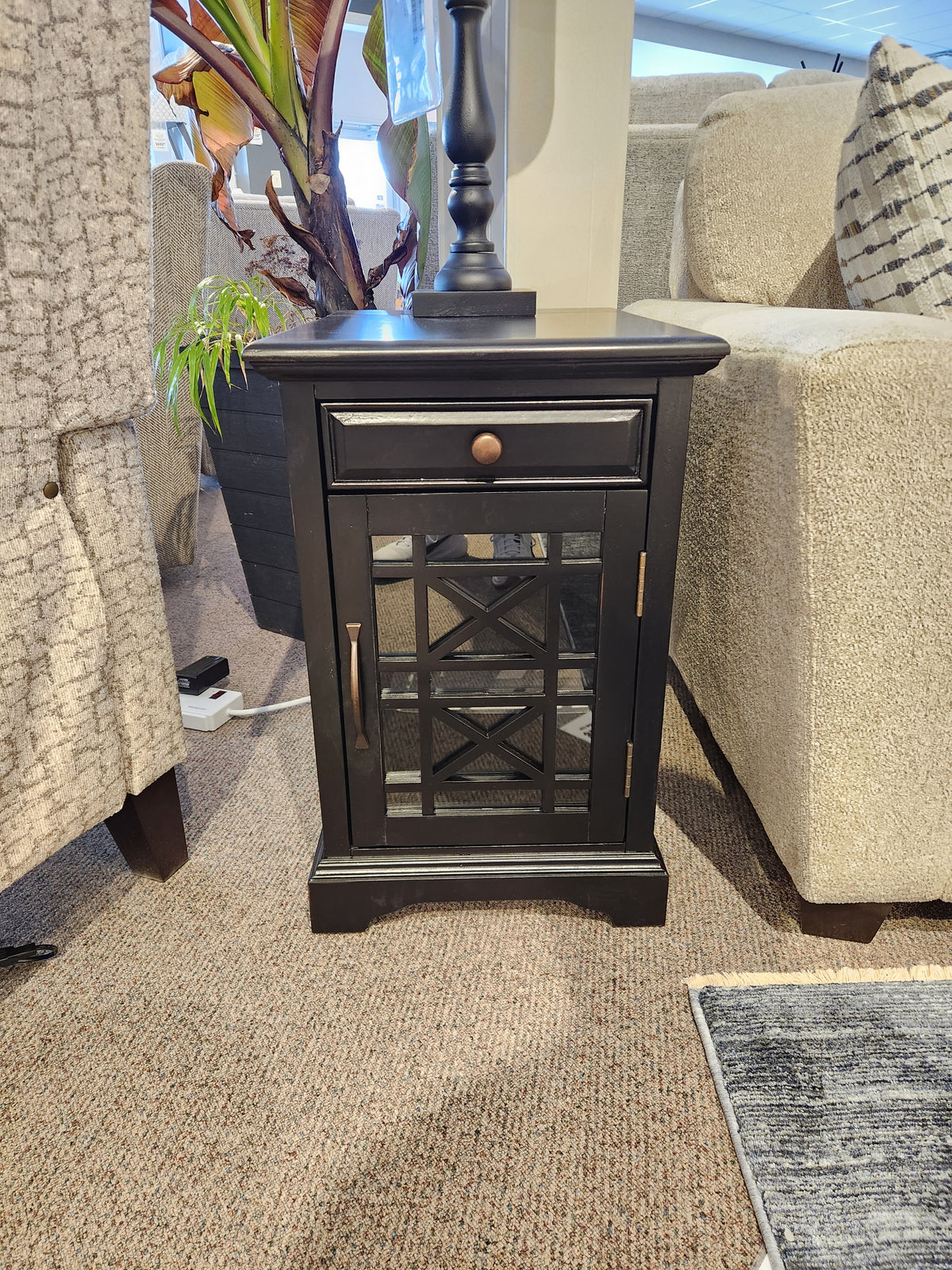 The Jofran 275 Craftsman Power Chairside End Table features antique hardware and a glass-panel door between sofas.