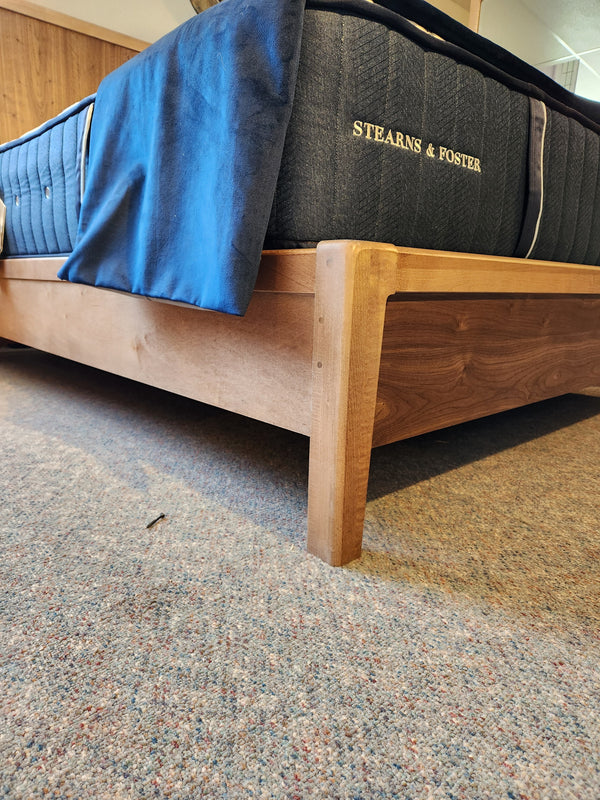 Vaughan Bassett 853 Nordhaven Queen Bed Frame with Stearns & Foster mattress, blue bedding, and carpeted floor—ideal for minimalists.