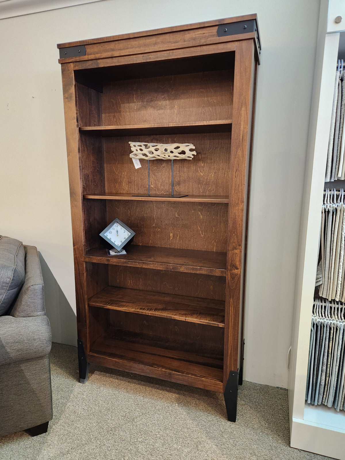 The Handstone CH80 Chattanooga 80" Bookcase in maple mocha with adjustable shelves holds a clock and driftwood.