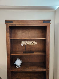 The Handstone CH80 Chattanooga 80" Bookcase in maple mocha has three shelves; the middle shelf is adjustable for display.