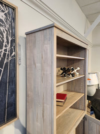 The Handstone CU80D-Cumberland Bookcase provides vertical storage for books and decor beside art on a white wall.