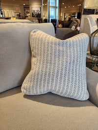 A striped pillow sits on the 638-610 Charlie Sofa by La-z-boy, featuring detached back pillows in a showroom.