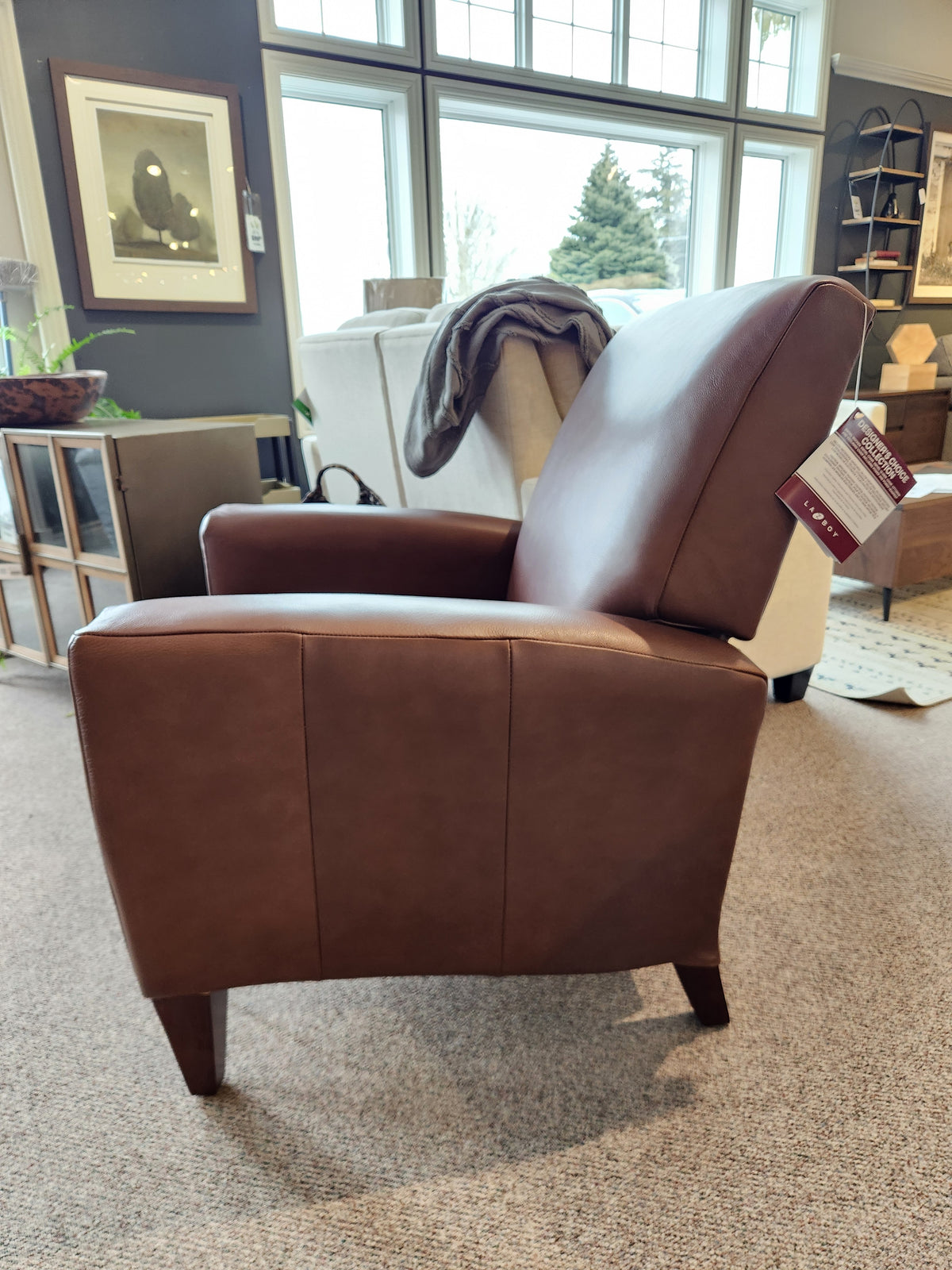 La-Z-Boy 431 Scarlett High-Leg Recliner in brown leather, featuring an angled backrest, shown in a showroom.