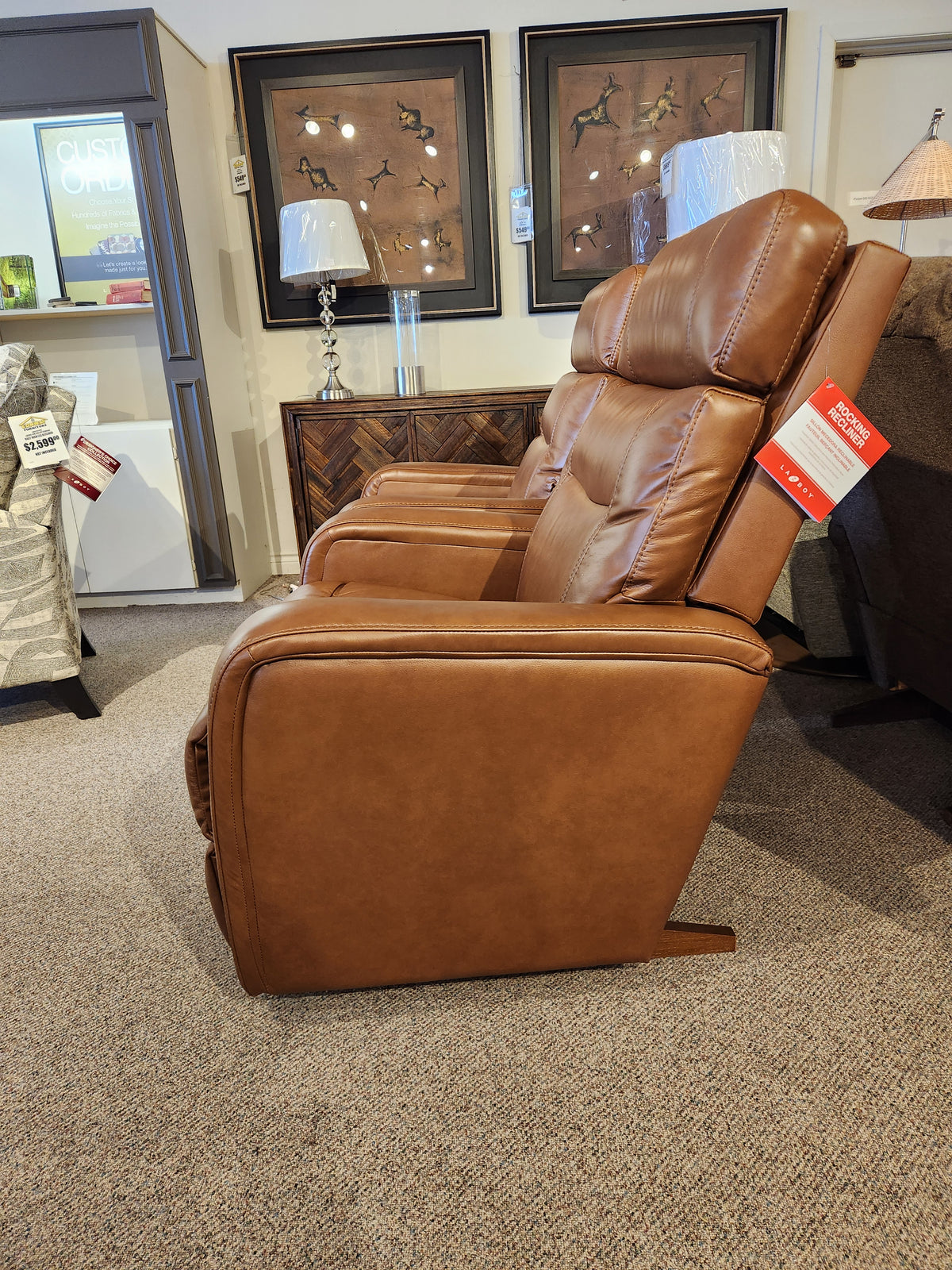 Side view of three La-Z-Boy 807 Baron Rocker Recliners with price tags displayed in a showroom.