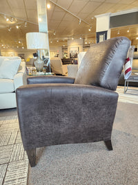 A dark brown La-z-boy 431 Scarlett High-Leg Recliner on display in a showroom, with other furniture in the background.