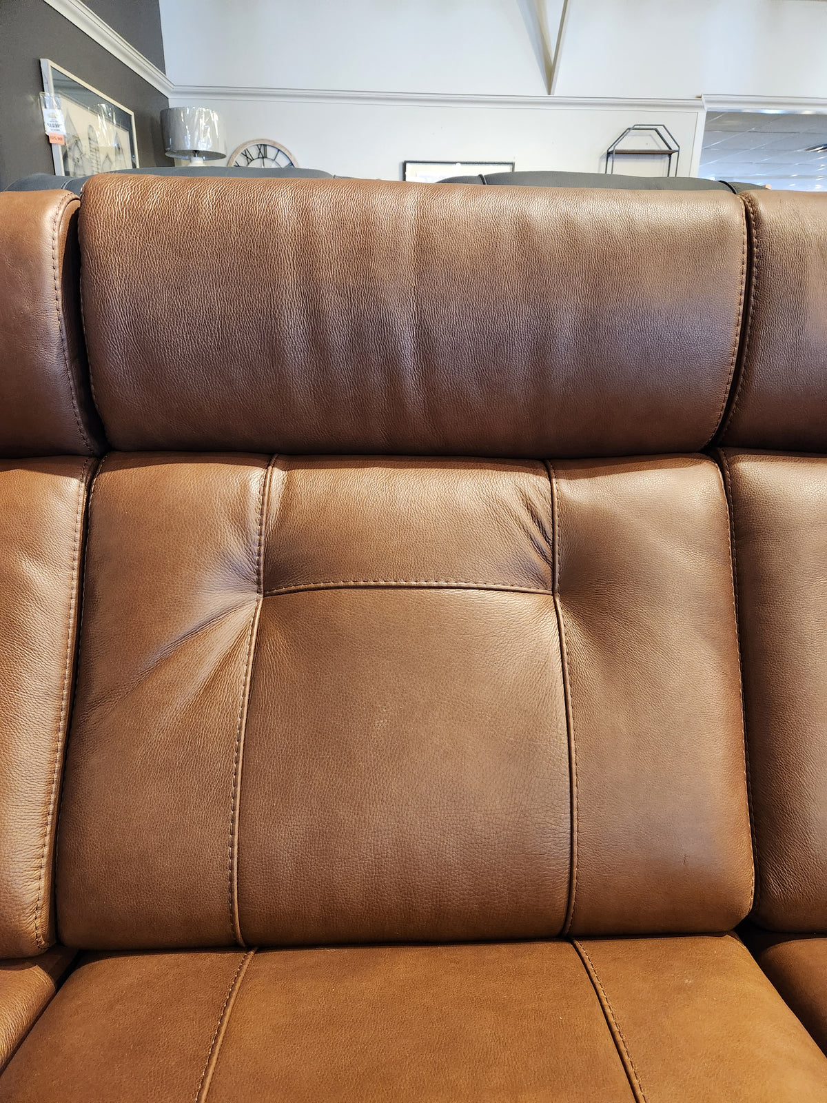 Close-up of the Palliser 42204 West Coast Power Reclining Sofa's leather backrest with stitching and tufted buttons.