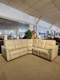 The Palliser Oxford 3-piece Sectional in beige leather with power recline is displayed amid decor and mirrors.