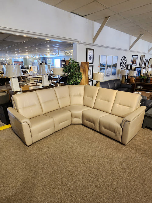 The Palliser Oxford 3-piece Sectional, an L-shaped beige leather sofa with power recline and headrest, on display.
