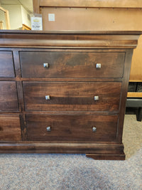 The Vokes 260 Louis Rustique 6 Drawer Dresser features dark wormy maple and square metal knobs, shown on carpet.