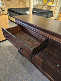 The Vokes 260 Louis Rustique 6 Drawer Dresser is displayed open amid traditional bedroom furniture in the showroom.