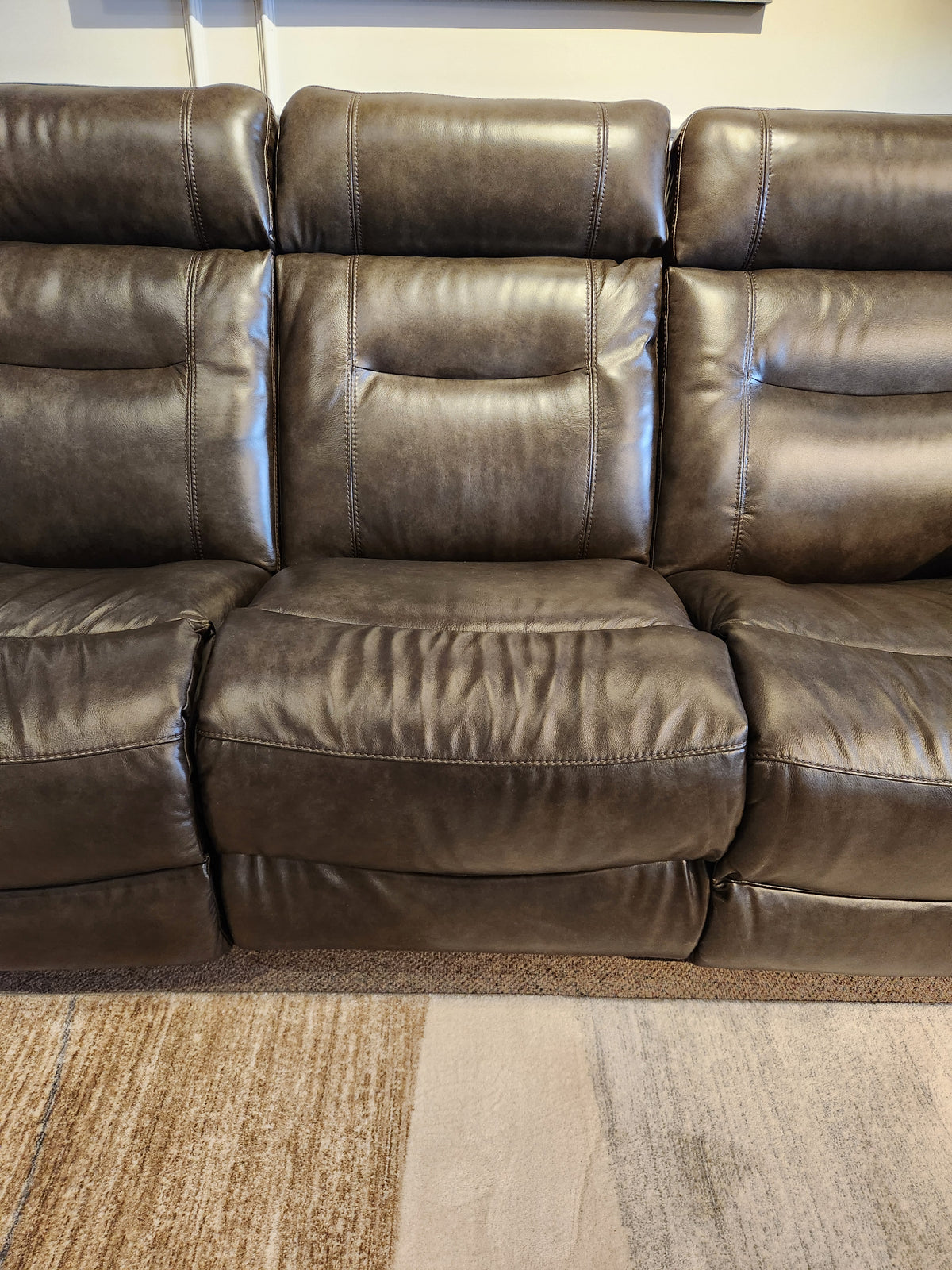 The La-Z-Boy 807 Baron Reclining Sofa in dark brown leather seats three on a beige and brown patterned rug.