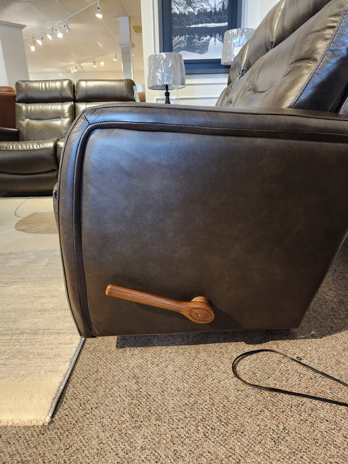 Side view of the La-Z-Boy 807 Baron Reclining Sofa with lumbar support and wooden lever handle in a showroom.