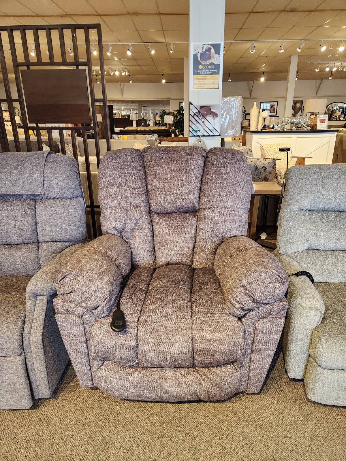 Best 6M52 Kona Power Lift Chair with overstuffed cushions and remote, shown in a furniture store showroom.