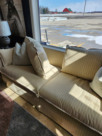 Best Oxford Sofa in beige stripes with down-blend cushions, placed by a window with a red barn and parking lot view.