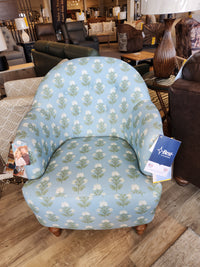 The Arden Club Chair by Best, button-tufted with a blue and white floral pattern, is on display with tags attached.