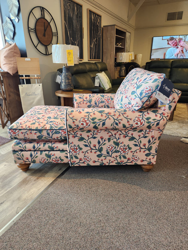 The Kress Chaise Lounge by Best features floral upholstery and wooden legs, bringing heirloom charm to your showroom.