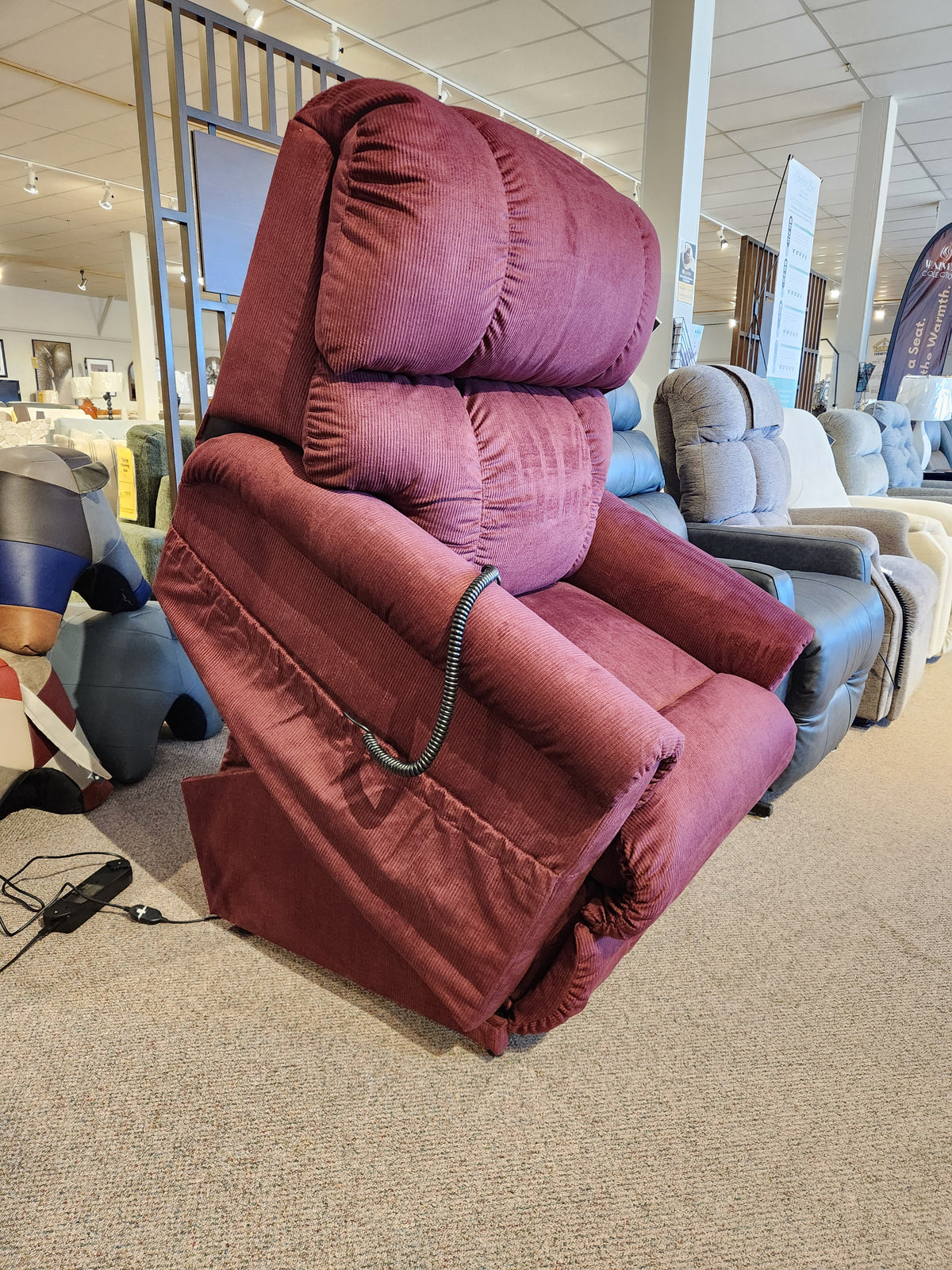 A La-z-boy 512 Pinnacle Platinum Luxury Lift Chair in burgundy reclined to zero-gravity is on display in-store.