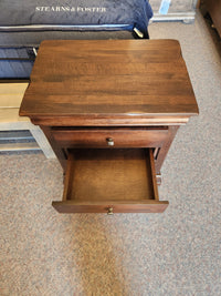 Vokes 260 Louis Rustique 3 Drawer Nightstand: wormy maple, closed top drawer, open bottom drawer on carpeted floor.