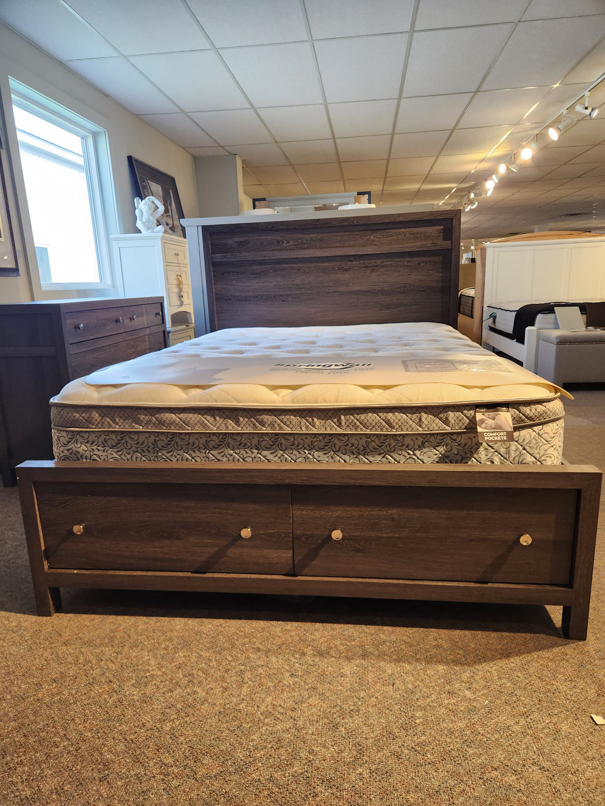 The Magnussen B6308 Merrifield Queen Storage Bed features a large headboard and two drawers, perfect for modern bedrooms.