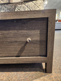 Close-up of a dark oak veneer drawer with round knob on the Magnussen B6308 Merrifield Queen Storage Bed.