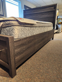The Magnussen B6308 Merrifield Queen Storage Bed is a modern wooden frame with a patterned mattress.