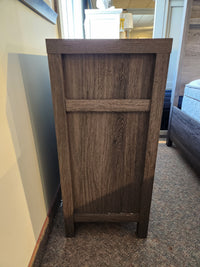 The Magnussen B6308 - Merrifield Dresser with an oak veneer back panel stands on a carpeted floor in a modern bedroom.