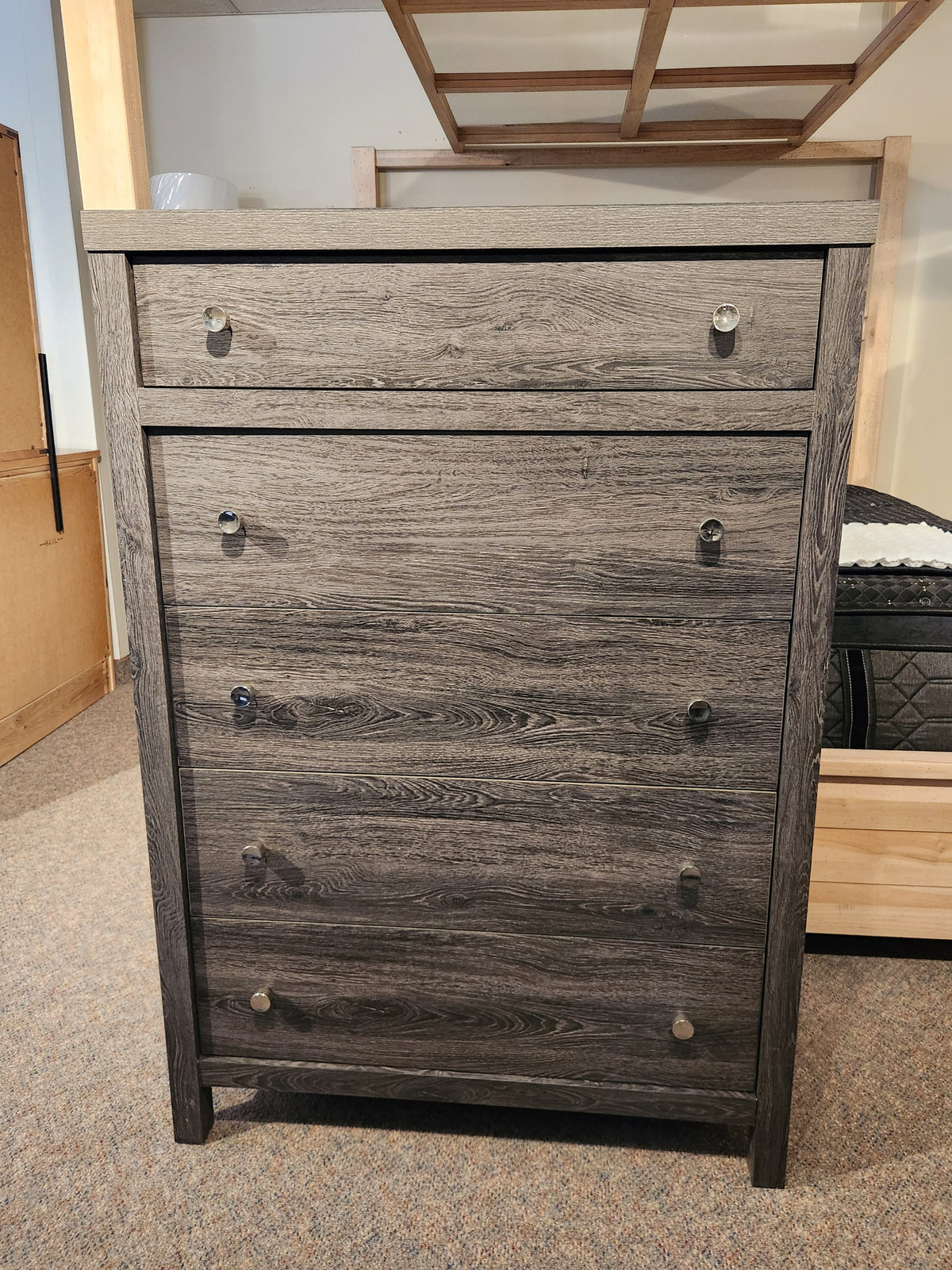 The Magnussen B6308 Merrifield Chest stands on carpet, ideal for modern bedrooms.