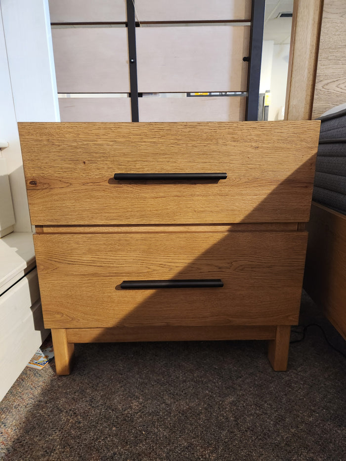 The Magnussen B6309 Davenport Nightstand in Rustic Caramel stands on a carpeted floor.