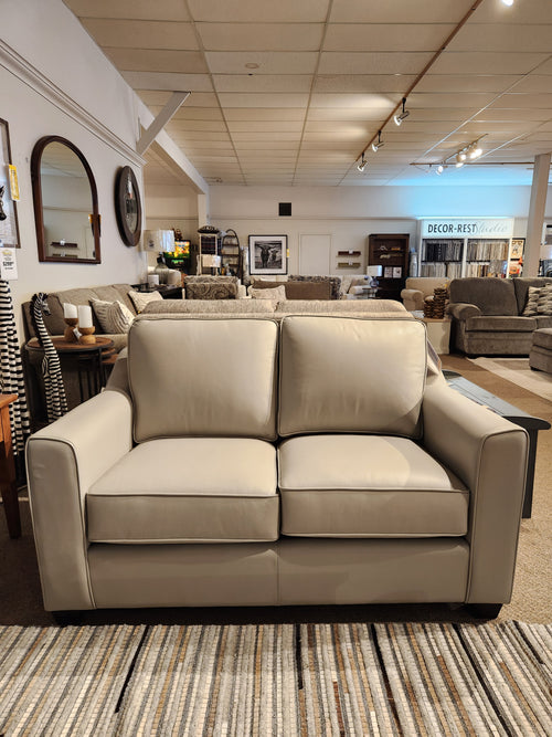 The Sophia Loveseat by Leather Craft is displayed among other sofas and decor in the furniture showroom.