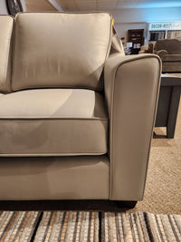 Close-up of a Sophia Loveseat by Leather Craft, highlighting exquisite Canadian leather in a showroom setting.