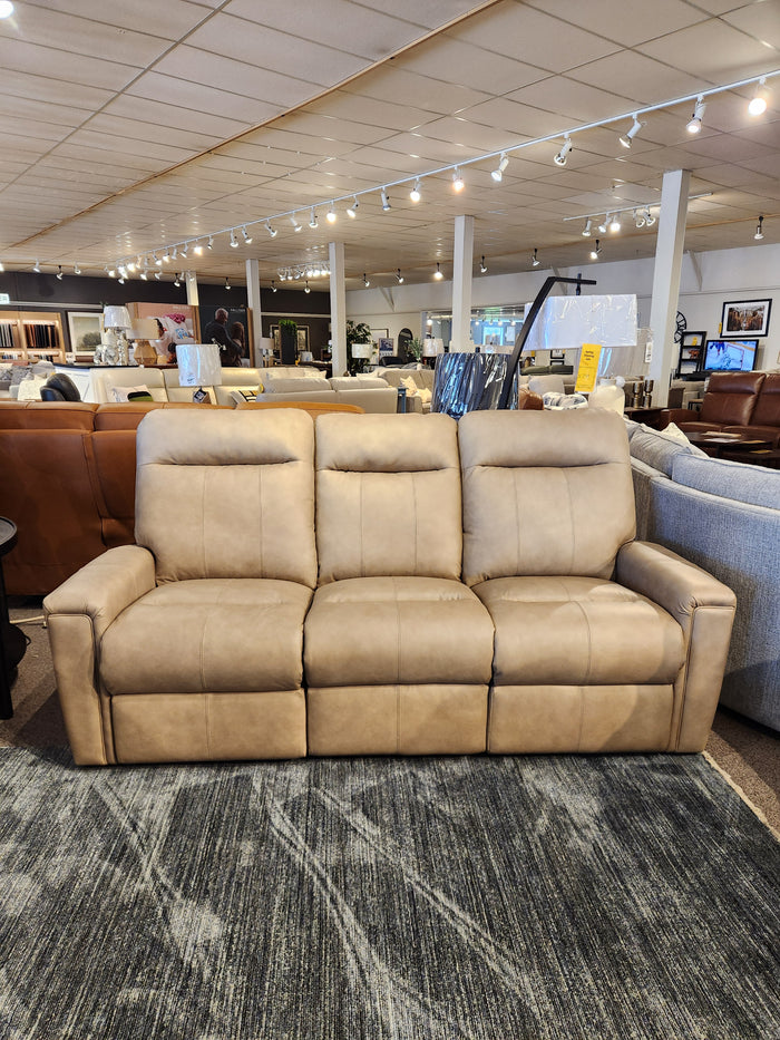 The Decor-rest M8520 Power Reclining Sofa in tan leather is shown on a dark textured rug in the showroom.