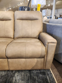The Decor-rest M8520 beige leather power reclining sofa is displayed on a gray rug under showroom lighting.
