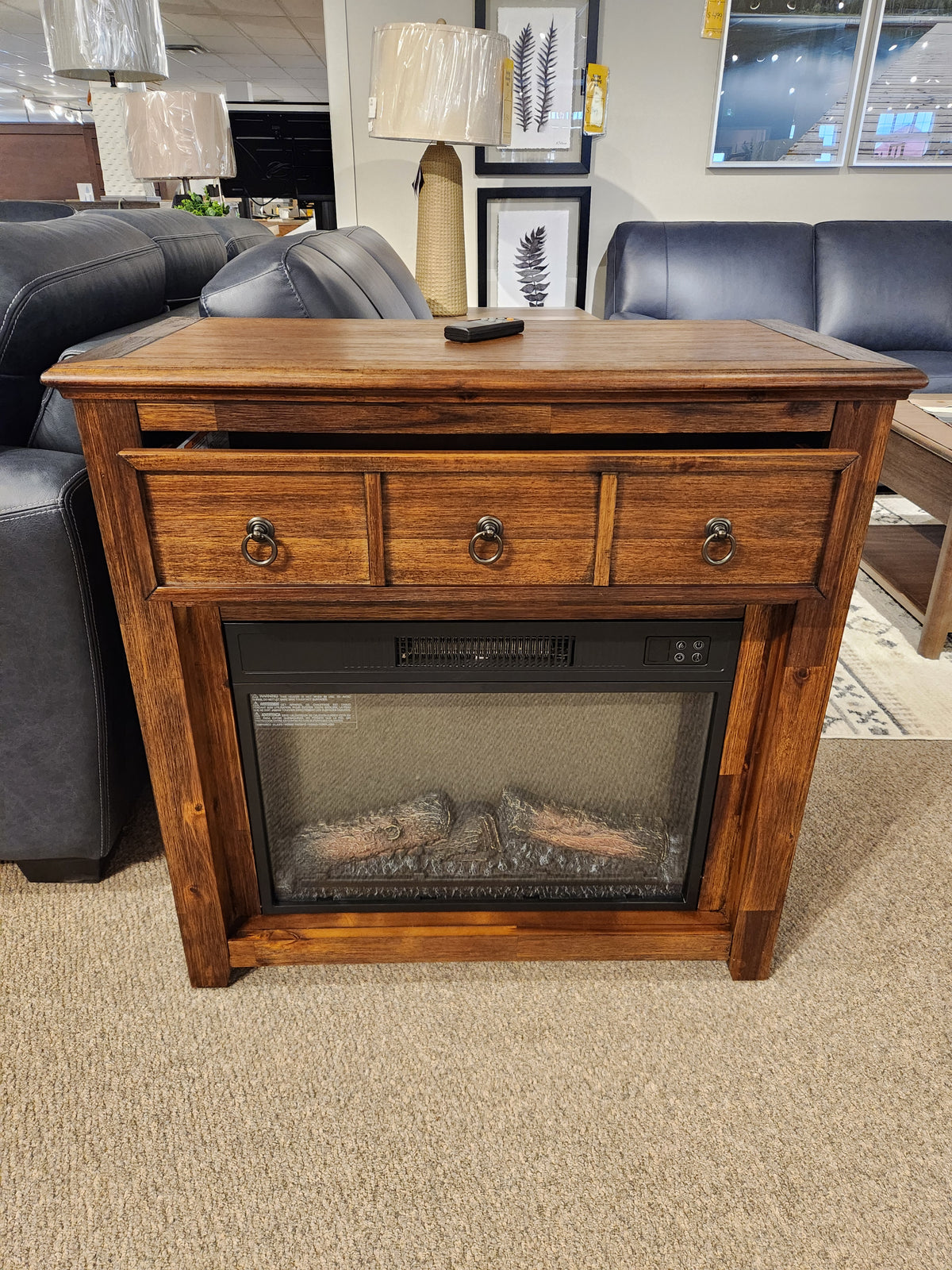 The Jofran 1900 Bakersfield 32" Fireplace features customizable flames and three drawers, shown with couches and decor.