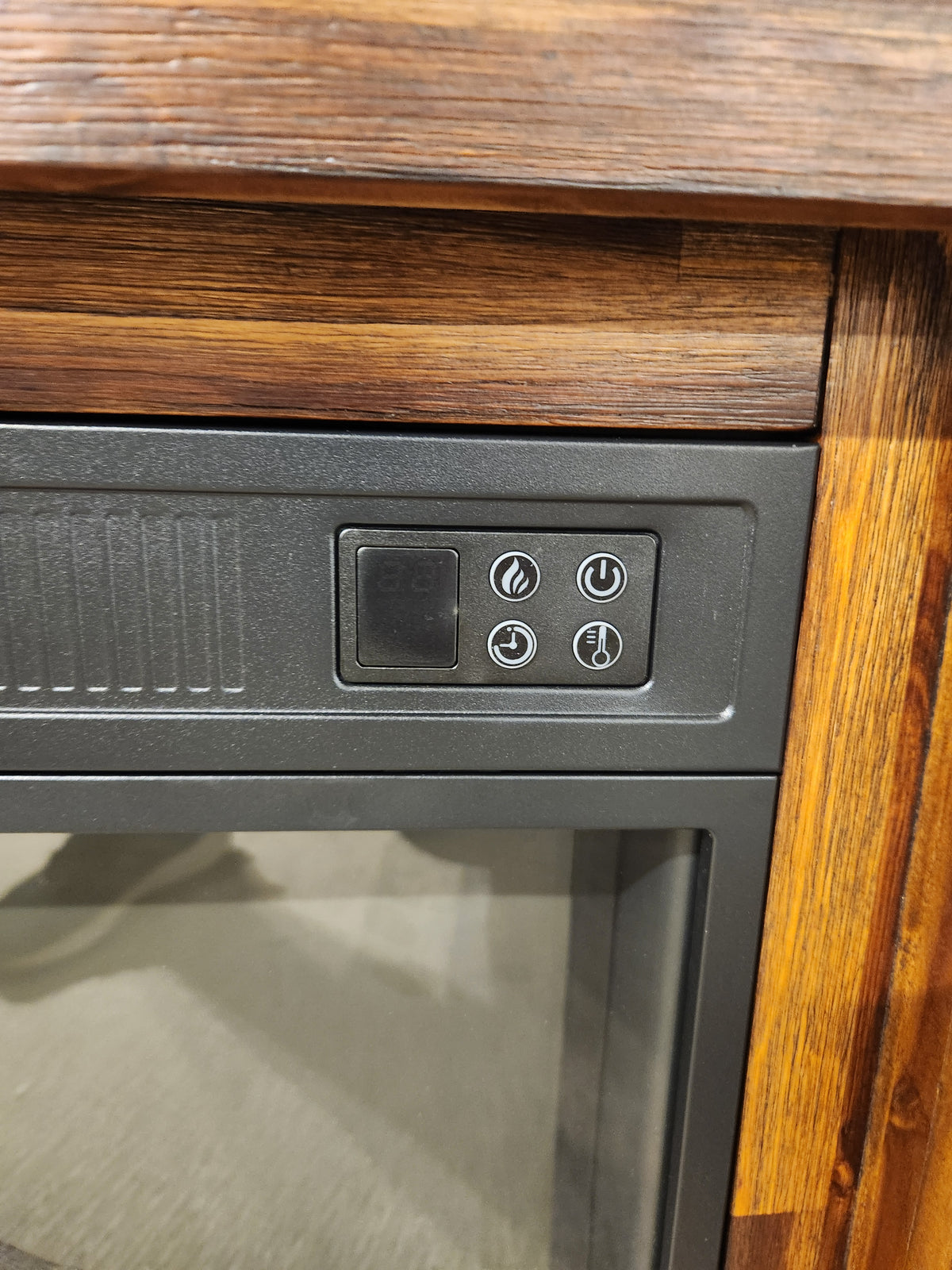 Close-up of Jofran's 1900 Bakersfield 32" Fireplace control panel with customizable flame, set in a wooden frame.