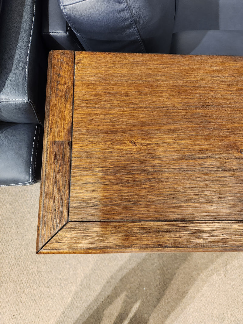 Dark wood coffee table beside gray leather sofa, near Jofran 1900 Bakersfield 32" fireplace with custom flame settings.