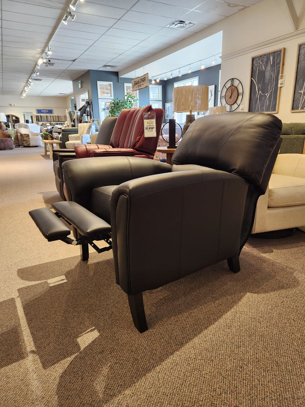 The Leather Craft 698 Reclining Chair is shown in a showroom with its black leather footrest elegantly extended.