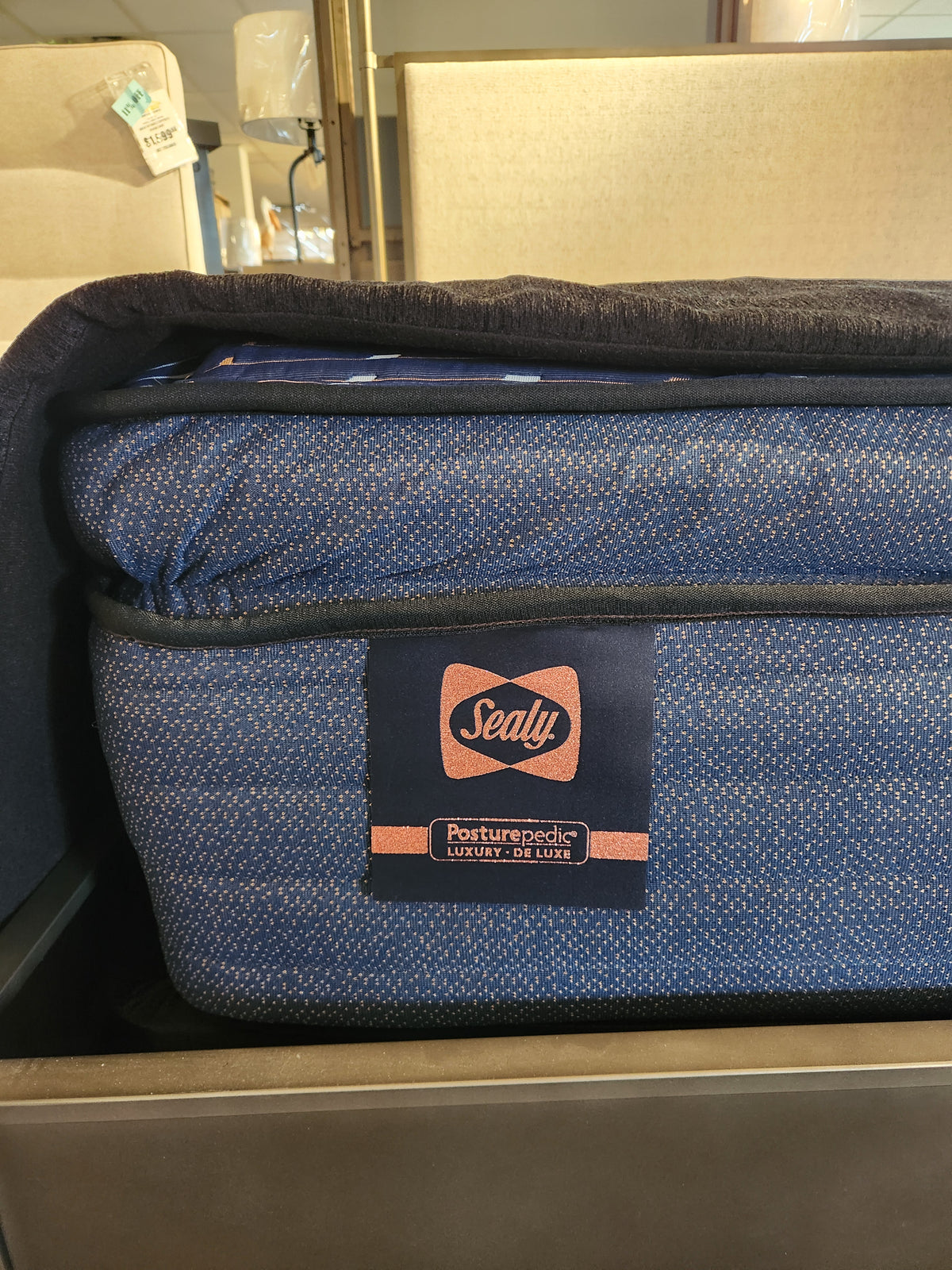 Close-up of a Sealy Roux ET Soft 1300 Coil Copper Series mattress with tag, offering pressure relief in-store.
