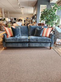 Adeline Sofa by Best: blue velvet, reversible seat cushions, striped pillows—shown in a furniture showroom.