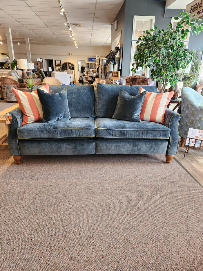 Adeline Sofa by Best: blue velvet, reversible seat cushions, striped pillows—shown in a furniture showroom.