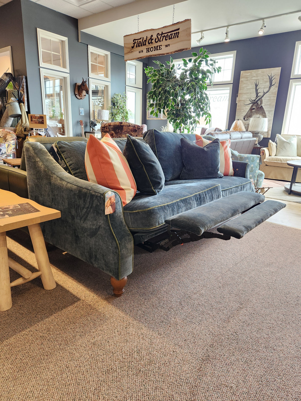 Best Adeline Sofa: blue upholstery, incliner, striped pillows, reversible cushions displayed in the showroom.