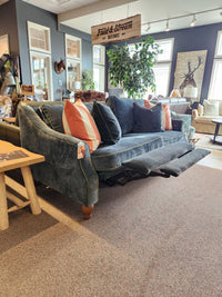 Best Adeline Sofa: blue upholstery, incliner, striped pillows, reversible cushions displayed in the showroom.