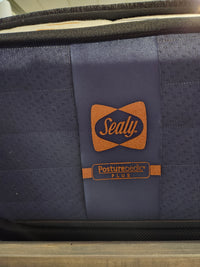 Sealy Cyra TT Firm Copper Series 1000 Coil mattress with branded labels on dark blue fabric panel.