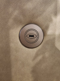 A round USB port is built into the textured tan Maverly S910 Space Saver Recliner Sofa by Best.
