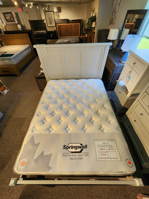 A Springwall Michelle ET Medium Mattress by Springwall displayed in a showroom with dressers and bedroom furniture.