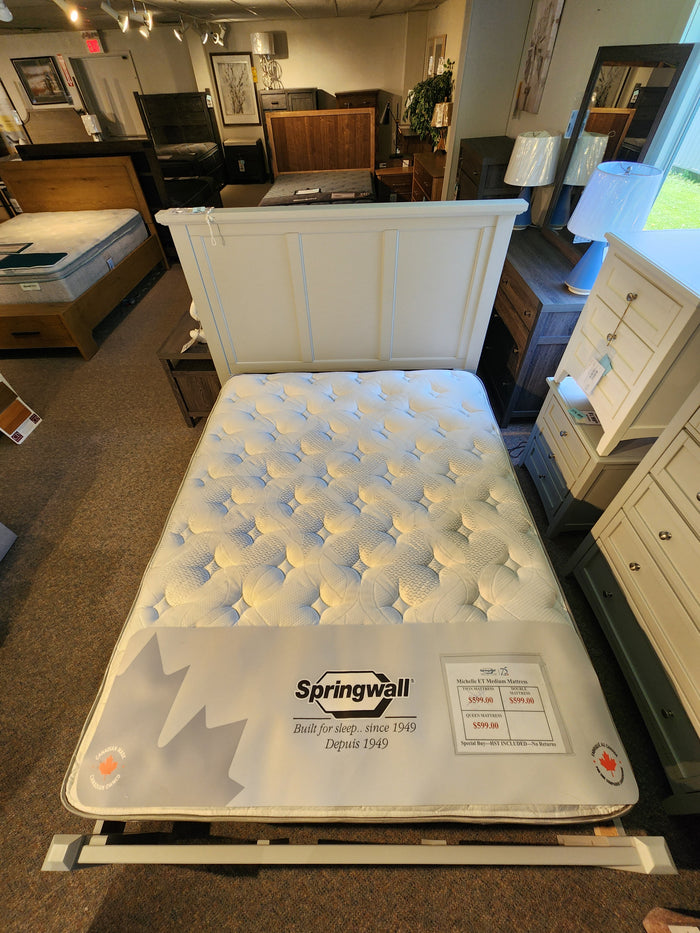 A Springwall Michelle ET Medium Mattress by Springwall displayed in a showroom with dressers and bedroom furniture.
